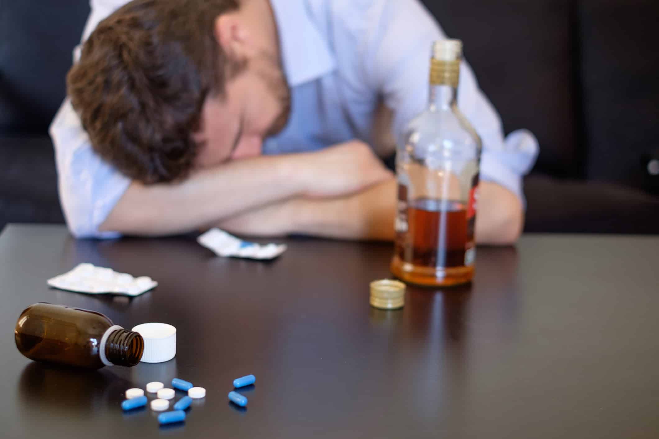 Depressed man mixing alcohol and pills