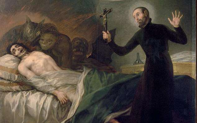 Priest performing exorcism to rid of negative entities attached to the person